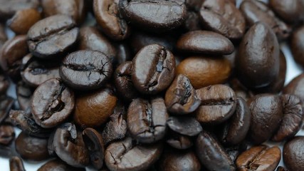 Wall Mural - Coffee beans rotating on white background. Close up