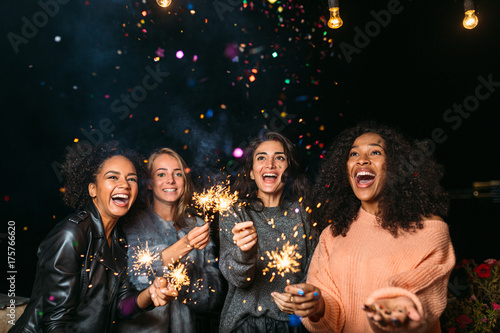 Zdjęcie XXL Żeńscy przyjaciele ma przyjęcia przy nocą outdoors, rzuca confetti
