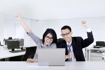 Wall Mural - Cheerful business team raise hands in office