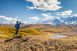 © beerkoff - A Man looking at the Mountains and a Lake below from Viewpoint.