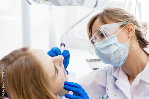 Plakat Młoda kobieta dentysta pracuje z pacjentem
