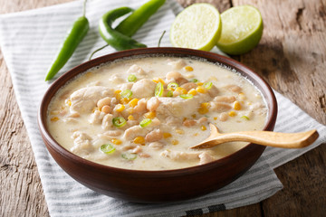 Wall Mural - Homemade white chili chicken with beans, lime and corn close-up. horizontal