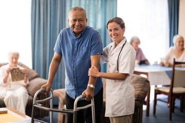 Wall Mural - Portrait of smiling female doctor standing by senior man with