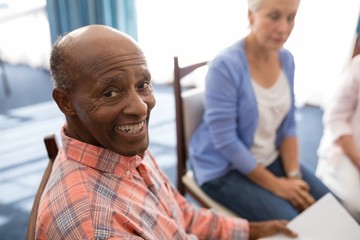 High angle portrait of smiling senior man sitting with females