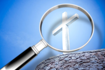 Looking for faith - concept image with a magnifying glass in front of a Christian cross