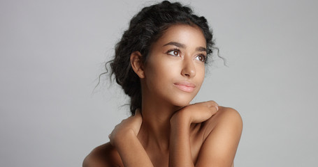 happy serene young woman with beautiful olive skin and curly hair ideal skin and brown eyes