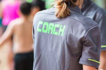 Wall Mural - back of a coach's grey shirt with the green word Coach written on it