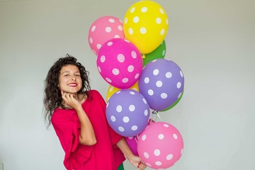 Beautiful cute cheerful girl with colored balloons. Holiday Happy Birthday