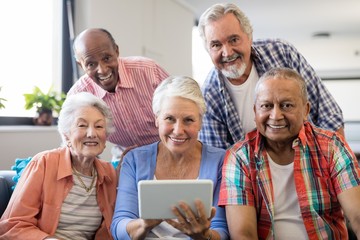 Wall Mural - Smiling senior people with digital tablet