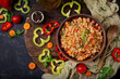 Vegetarian crumbly pearl barley porridge with vegetables  in a dark background. Flat lay. Top view