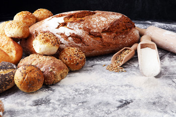 Different kinds of bread and bread rolls on black board. Kitchen or bakery poster design