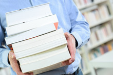 Body Of Man Holding Stack Of Books