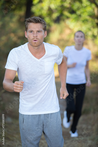 Plakat zawodnicy biegający w lesie na zawodach wytrzymałościowych