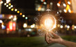 canvas print picture - Hand holding light bulb in front of global, show the world's consumption with icons energy sources for renewable, Ecology concept. Elements of this image furnished by NASA.
