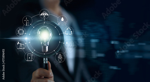 Cuadros en Lienzo Man holding magnifying glass and light bulb ,searching global show the world's c