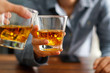 © ipopba - Close-up two men clinking whiskey glasses  beverage together at counter bar in pub