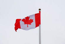 Developing The Flag Of Canada Against A Gray Sky