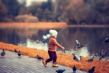 Little Girl In The Autumn Park, Runing With Pigeons.