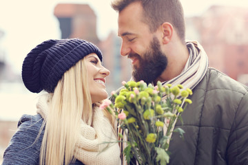 Wall Mural - Picture showing young couple with flowers dating in the city