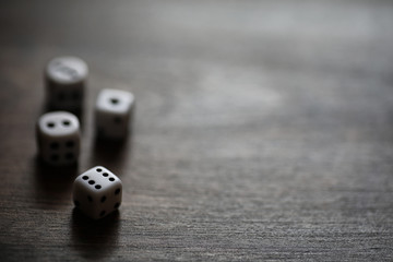 White dices on a brown wooden texture table