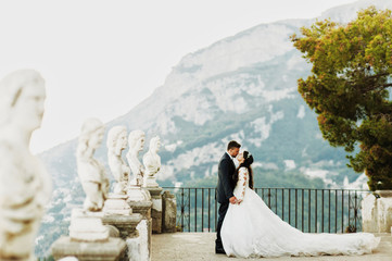 bride and groom kiss standing on the old stone balcony