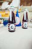 Fototapeta Młodzieżowe - Bottles with cherry lemonade decorated with boats and anchors