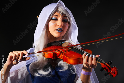 Plakat Piękna dziewczyna w stroju elfa ze skrzypcami na szarym tle. Oryginalny charakter cosplay