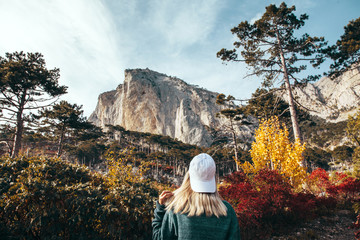Wall Mural - girl traveling in autumn forest by the mountain