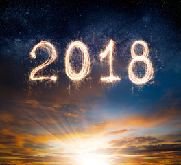 Wall Mural - 2018 written with sparkle firework on sunset sky background ,2018 happy new year background concept.