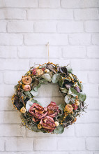 Dry Flowers Ring Hanged On A White Wall