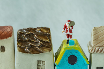 Wall Mural - Macro view of miniature figure Santa claus standing on roof chimny as christmas celebration concept