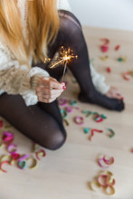 From Above - Woman Holding A Sparkler At Home With Confetti On The Floor