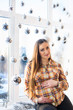 © Nestyda - Beautiful pregnant girl with Big belly near the window on a Christmas, having a rest on Christmas holidays before the new year. the concept of a new life