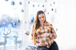 © Nestyda - Beautiful pregnant girl with Big belly near the window on a Christmas, having a rest on Christmas holidays before the new year. the concept of a new life