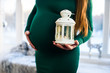 © Nestyda - Beautiful pregnant girl with Big belly near the window on a Christmas, having a rest on Christmas holidays before the new year. the concept of a new life