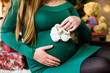 © Nestyda - Beautiful pregnant girl on the background of a Christmas tree, having a rest on Christmas holidays before the new year. Big pregnant belly