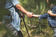 © boonchok - The hiking man is pulling his lover hand to help prevent falling while hiking.
