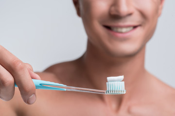 Wall Mural - Happy guy is standing with dental tool