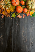 Autumn Background With Pumpkins, Autumn Leaves, Hops And Oak Acorns Lying On A Black Wooden Background