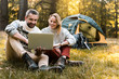 © Yakobchuk Olena - Cheerful man and woman using portable computer in the nature