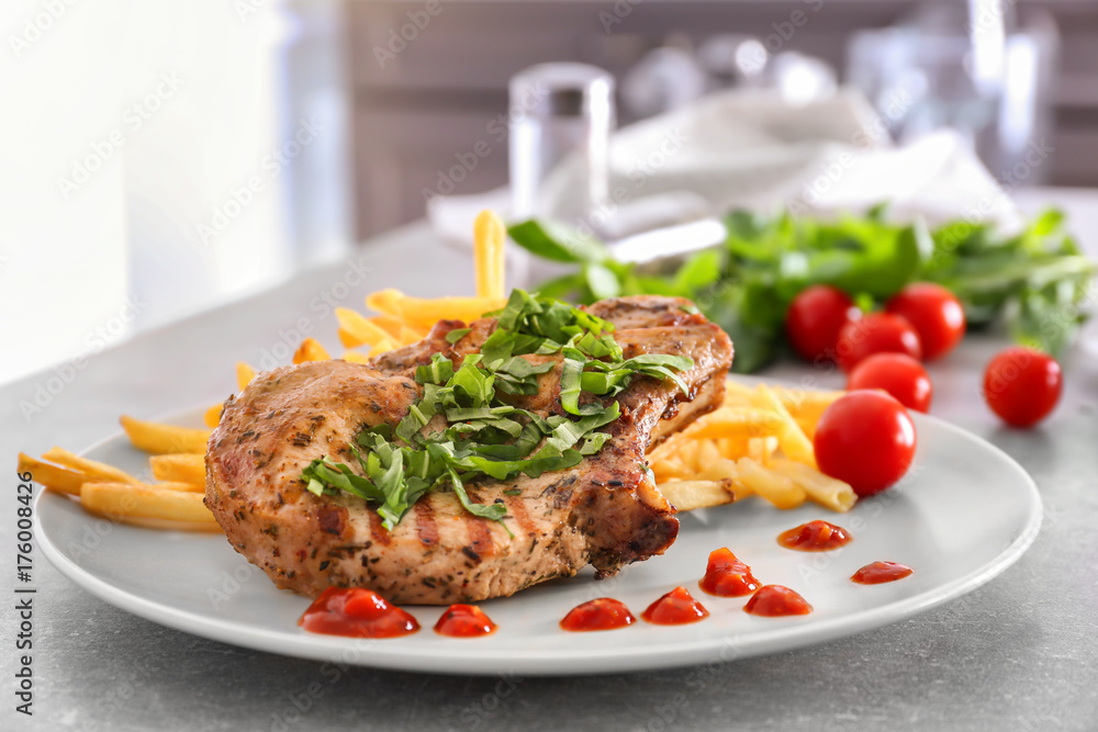 Plate with delicious grilled steak frites on kitchen table