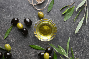 Glass bowl with olive oil on dark background