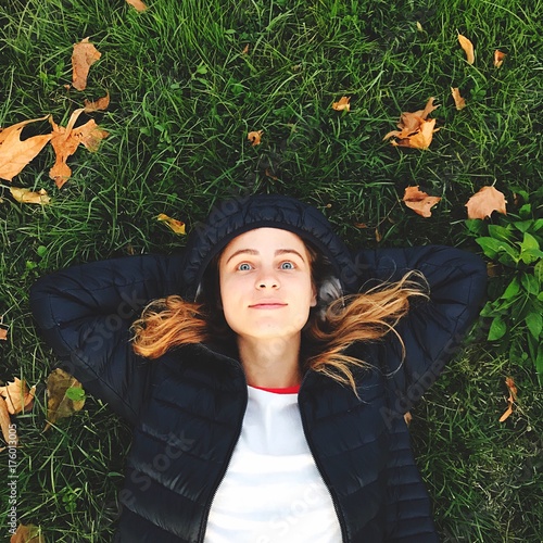 Fotografía ragazza sdraiata sull’erba guarda il cielo