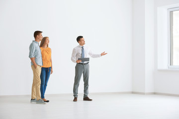 Canvas Print - Real estate broker showing young couple a new flat