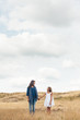 © Cindy Prins/Stocksy - Mother and daughter standing in a golden field underneath a big cloudy sky