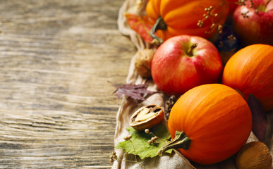 Poster - Autumn pumpkins and apples with fall leaves on wooden background with copy space. Autumn composition