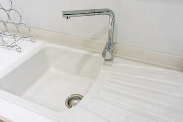 Wall Mural - modern rectangular stainless steel faucet and white sink on a granite worktop in a new kitchen