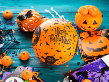 Halloween Decoration Symbols On Dark Rustic Wooden Background. Wishing Happy Holiday With Orange Balloon