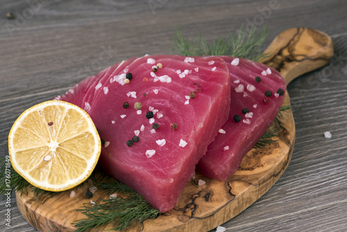 Plakat Surowy filet z tuńczyka z koprem, cytryną i papryką w oliwek deska do krojenia