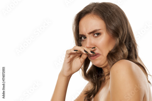 Photographie Portrait of beautiful young disgusted woman on white background